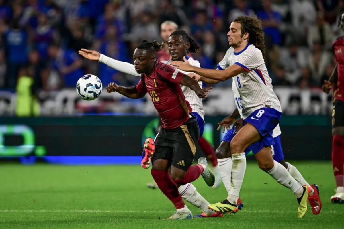 Belgium's forward #10 Jeremy Doku (L) fights for the ball with France's midfielder #08 Matteo Guendouzi (R) and France's midfielder #06 Manu Kone (C) during the UEFA Nations League, League A - Group 2 first leg football match between France and Belgium at the Parc Olympique Lyonnais in Lyon on September 9, 2024.  Olivier CHASSIGNOLE / AFP