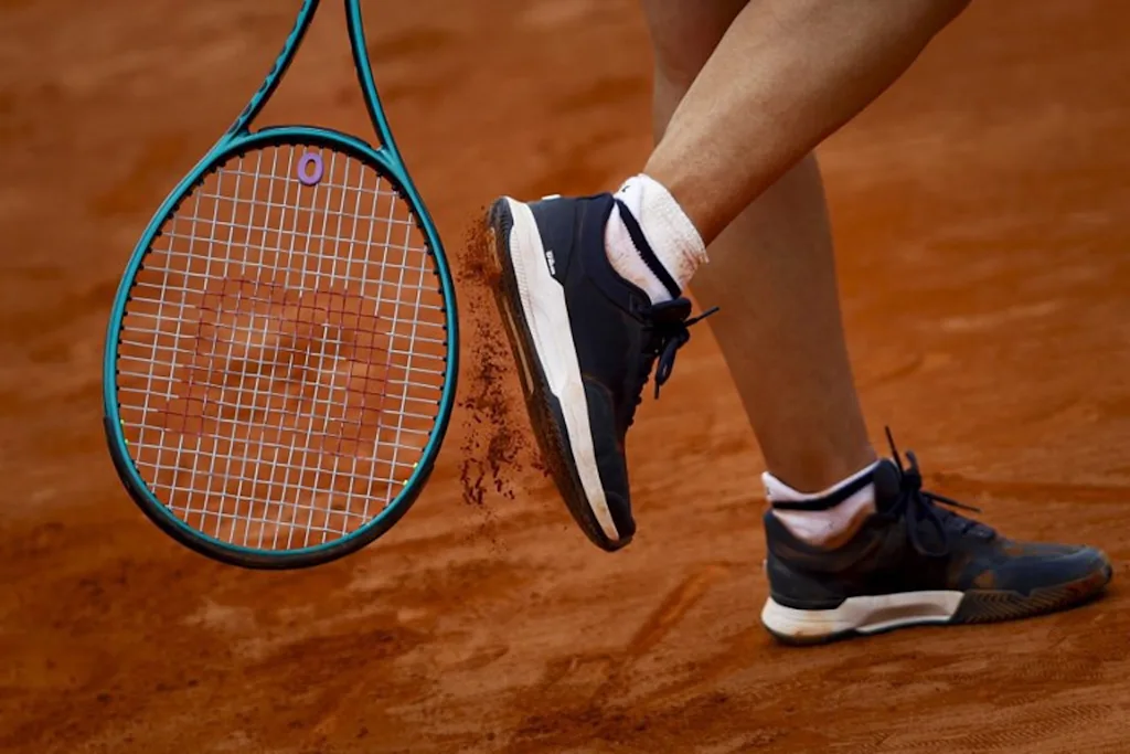 France's Leolia Jeanjean taps her shoe with her racket during her women's singles match against Romania's Elena Ruxandra Bertea at the Billie Jean King Cup play-offs between France and Romania, at Oeiras on the outskirts of Lisbon, on April 9, 2026.  FILIPE AMORIM / AFP
