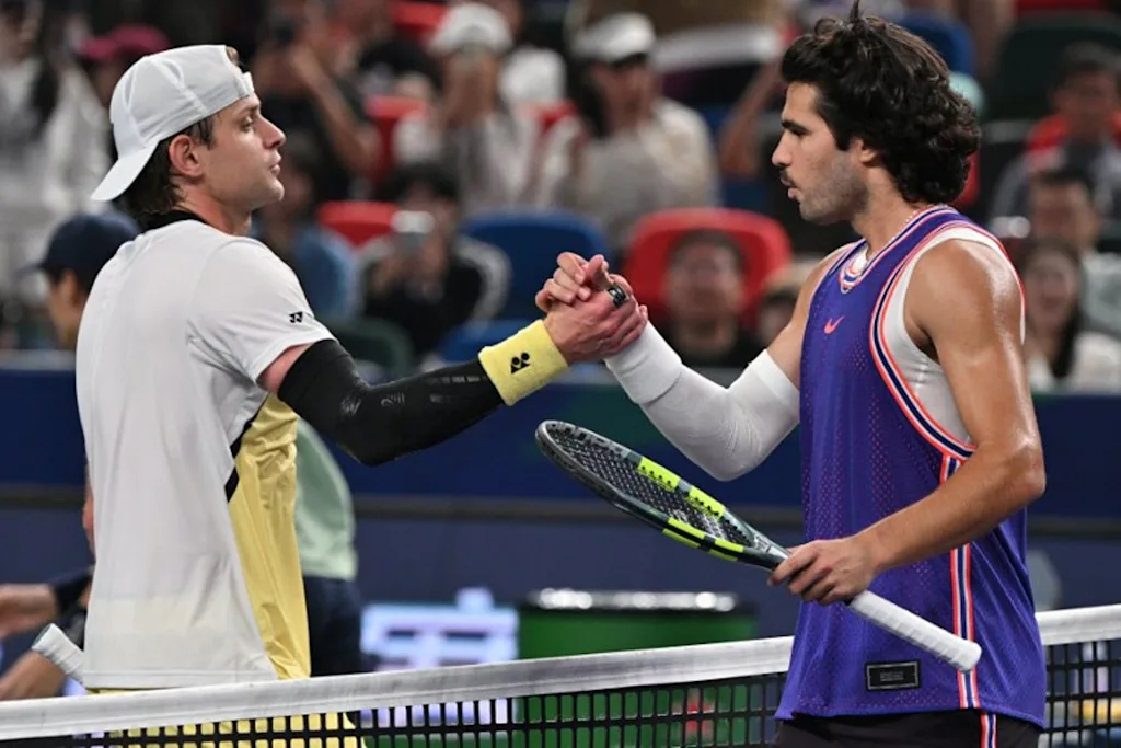 Belgium's Zizou Bergs (L) shakes hands with Spain's Carlos Alcaraz at the end of their men's singles match at the Shanghai Masters tennis tournament in Shanghai on October 12, 2026.  Hector RETAMAL / AFP