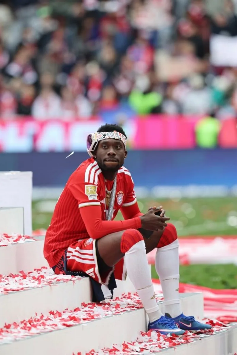 Bayern Munich's Canadian defender #19 Alphonso Davies sits on the stairs during celebrations for the Bundesliga trophy after wining the German first division Bundesliga football match between FC Bayern Munich and FC Cologne in Munich, southern Germany, on May 16, 2026. Alexandra BEIER / AFP