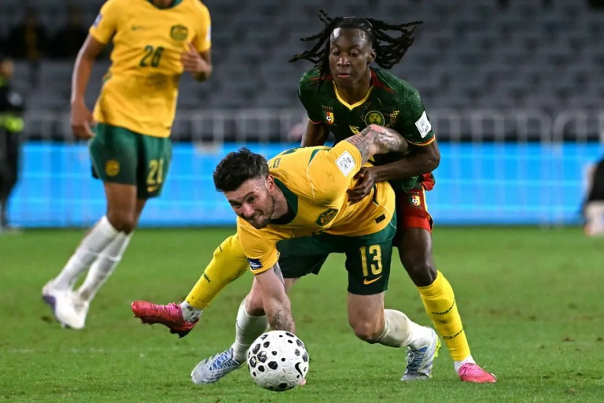 Australia's Aiden O'Neill (L) reacts after being tackled by Cameroon's Ryan Fosso (R) during the international friendly football match between Australia and Cameroon at Stadium Australia in Sydney on March 27, 2026. SAEED KHAN / AFP