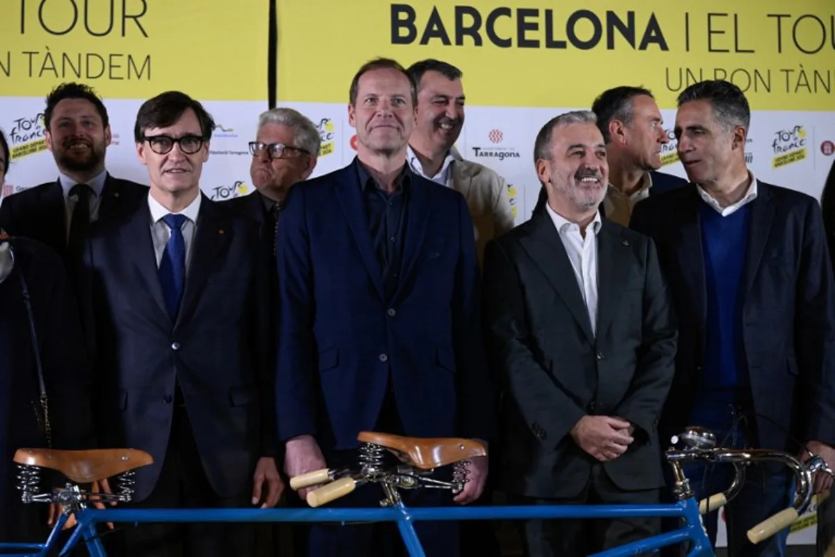 Tour de France general director Christian Prudhomme (C) is flanked by Barcelona's mayor Jaume Collboni (2R) and regional Catalonia President Salvador Illa (L) along with five-time Tour de France winner Miguel Indurain (R) during a ceremony in Barcelona to present the start of the 2026 Tour de France cylcling race from Barcelona, on February 25, 2025. The 2026 Tour de France cycling race's Grand Depart first stage will be held in Barcelona on July 4, 2026 with Spain's north eastern Catalonia region also hosting the second and third stages of La Grand Boucle. Josep LAGO / AFP