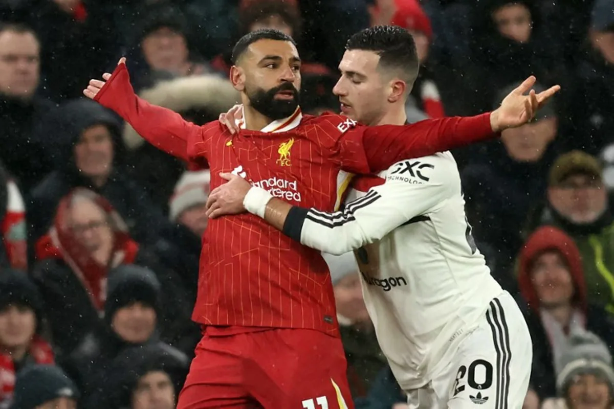 Manchester United's Portuguese defender #20 Diogo Dalot (R) is booked for holding back Liverpool's Egyptian striker #11 Mohamed Salah (L) during the English Premier League football match between Liverpool and Manchester United at Anfield in Liverpool, north west England on January 5, 2025.  Darren Staples / AFP