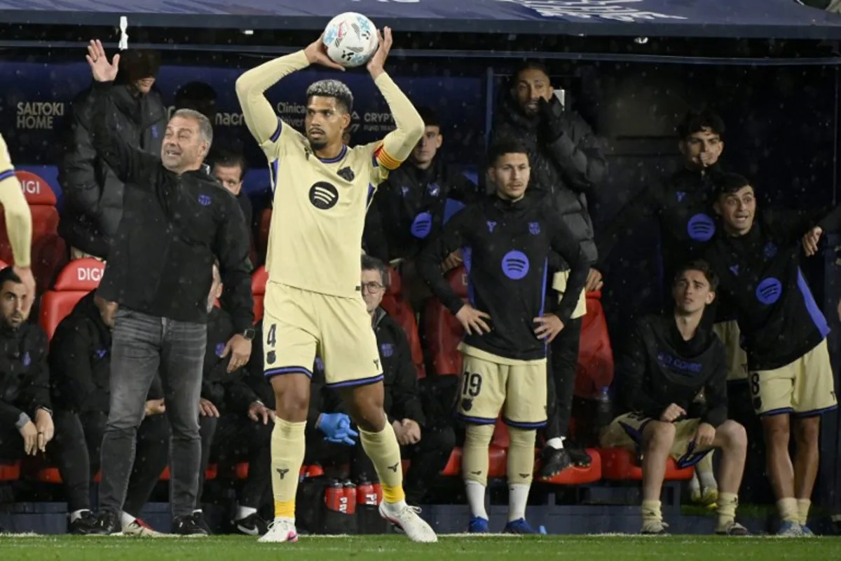 Barcelona's German coach Hans-Dieter Flick (L) gestures as Barcelona's Uruguayan defender #04 Ronald Federico Araujo da Silva takes a throw-in during the Spanish league football match between CA Osasuna and FC Barcelona at El Sadar Stadium in Pamplona on May 2, 2026. ANDER GILLENEA / AFP