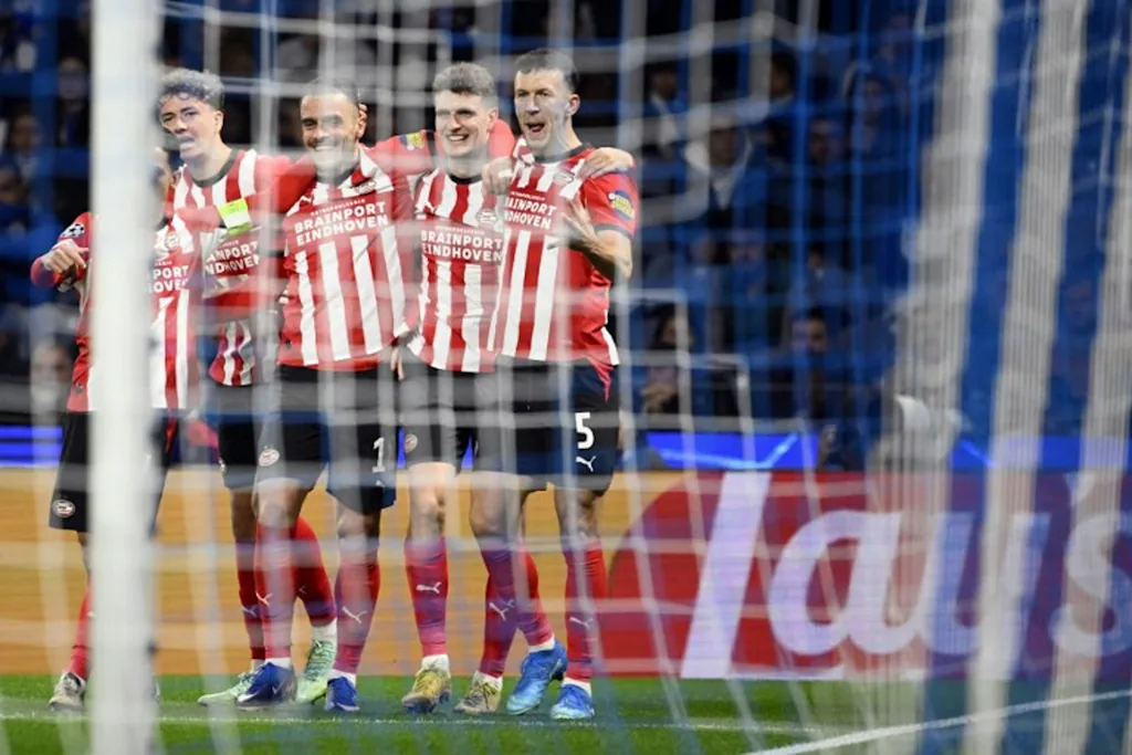 PSV Eindhoven's Dutch midfielder #20 Guus Til (2R) celebrates with teammates after scoring the opening goal during the UEFA Champions League first round day 3 football match between FC Porto and PSV Eindhoven at Dragao stadium in Porto, on October 20, 2026  Miguel RIOPA / AFP