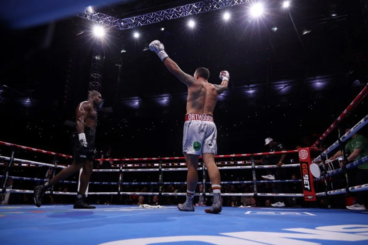 Ukraine's Oleksandr Usyk (R) celebrates defeating Britain's Daniel Dubois in their undisputed world heavyweight boxing title bout at Wembley Stadium in London on July 19, 2025. Adrian Dennis / AFP