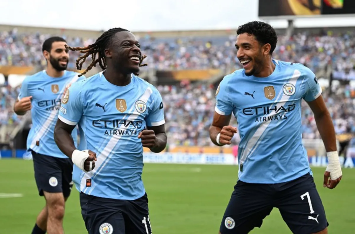 Manchester City's Belgian midfielder #11 Jeremy Doku celebrates after scoring the openin goal with teammate Egyptian striker #07 Omar Marmoush during the FIFA Club World Cup 2025 Group D football match between US Los Angeles FC and Brazil's CR Flamengo at the Camping World stadium in Orlando on June 24, 2025. PATRICIA DE MELO MOREIRA / AFP