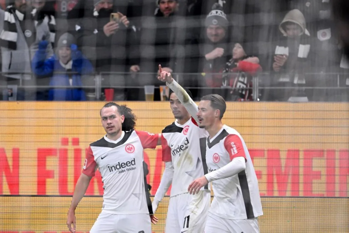 Frankfurt's French forward #11 Hugo Ekitike (C), Frankfurt's German defender #04 Robin Koch (R) and Frankfurt's Belgian defender #03 Arthur Theate celebrate scoring the 1-0 goal during the German first division Bundesliga football match between Eintracht Frankfurt and Borussia Dortmund in Frankfurt am Main, western Germany on January 17, 2025.  Kirill KUDRYAVTSEV / AFP