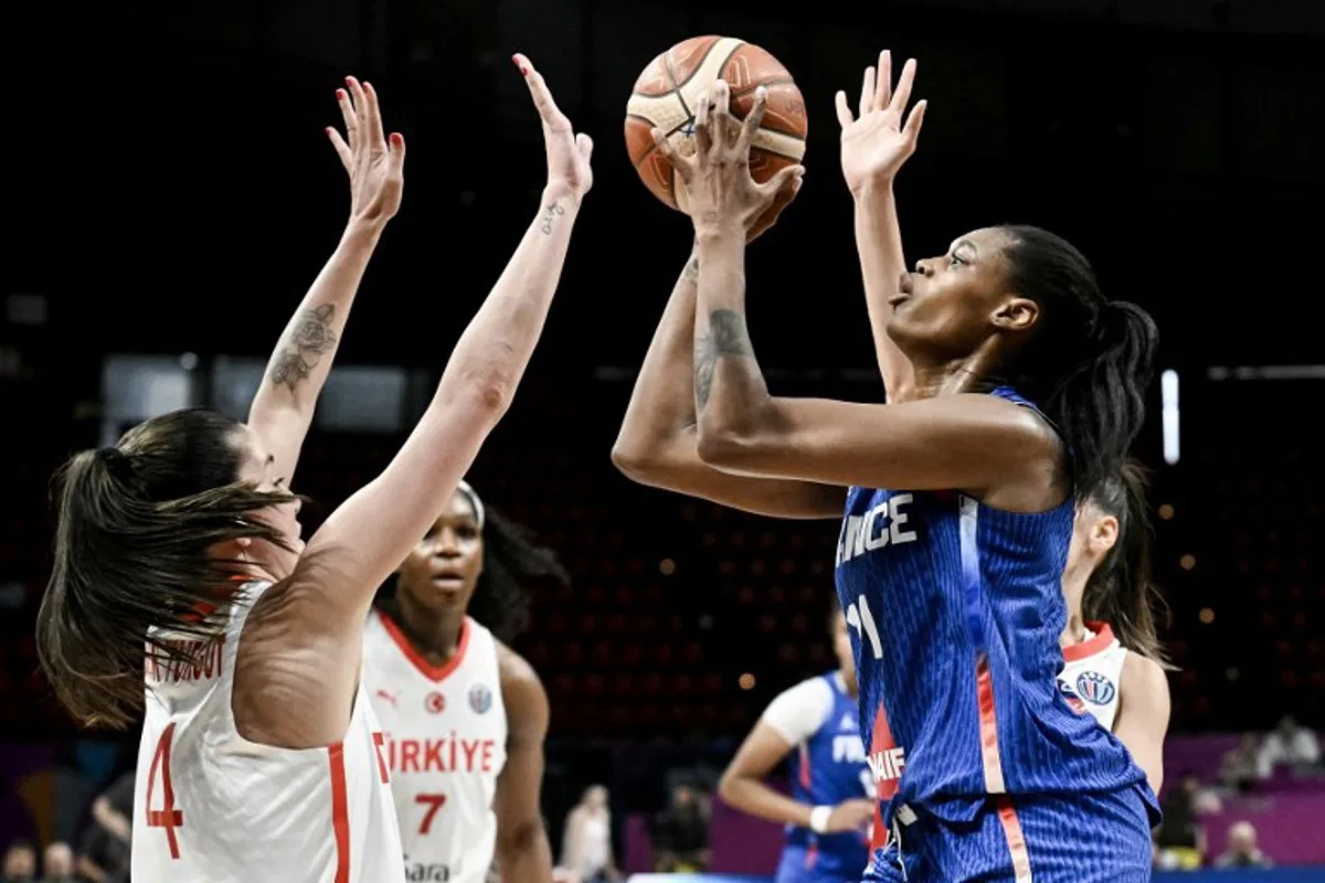 France's small forward Valeriane Ayayi (R) shoots in front of Turkey's point guard Olcay Cakir (L) during the FIBA Women's EuroBasket 2025 match between France and Turkey at the Peace and Friendship Stadium in Athens on June 18, 2025. Angelos Tzortzinis / AFP