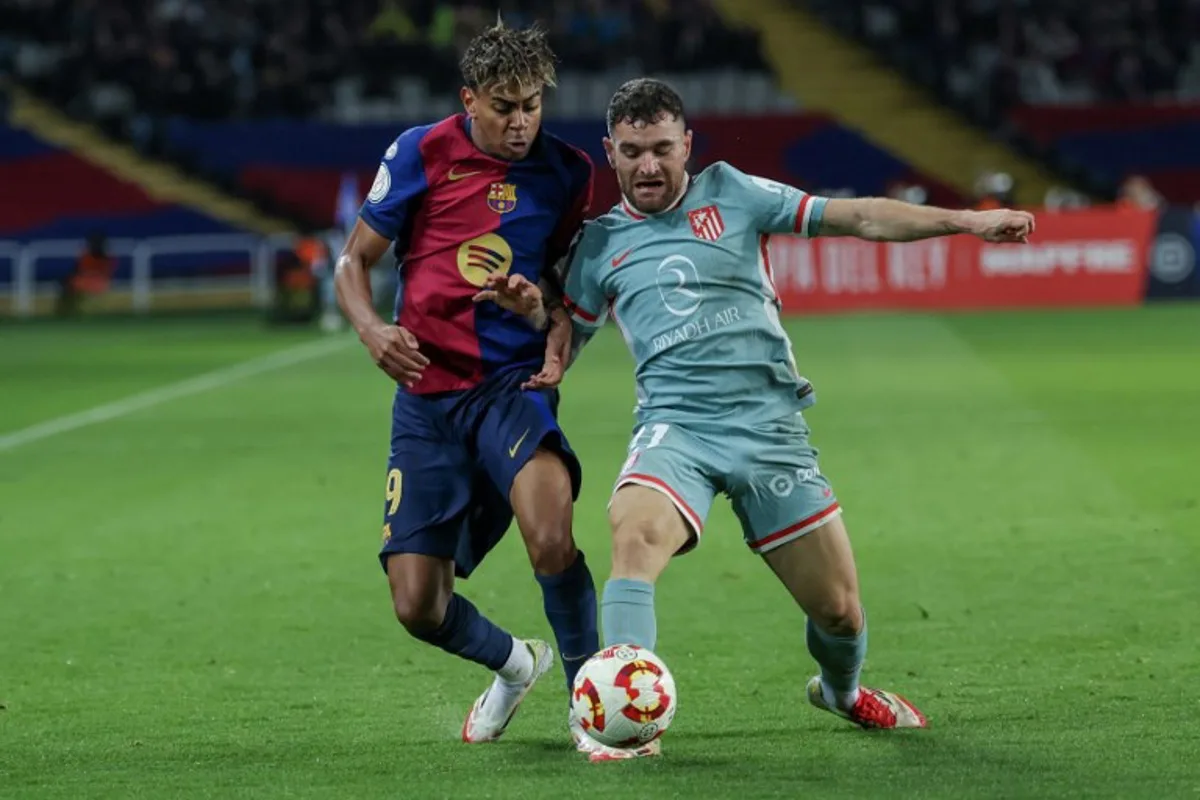 Barcelona's Spanish forward #19 Lamine Yamal (L) vies for the ball with Atletico Madrid's Spanish defender #21 Javi Galan during the Spanish Copa del Rey (King's Cup) semi-final first leg football match between FC Barcelona and Club Atletico de Madrid at at Estadi Olimpic Lluis Companys in Barcelona, on February 25, 2025.  LLUIS GENE / AFP