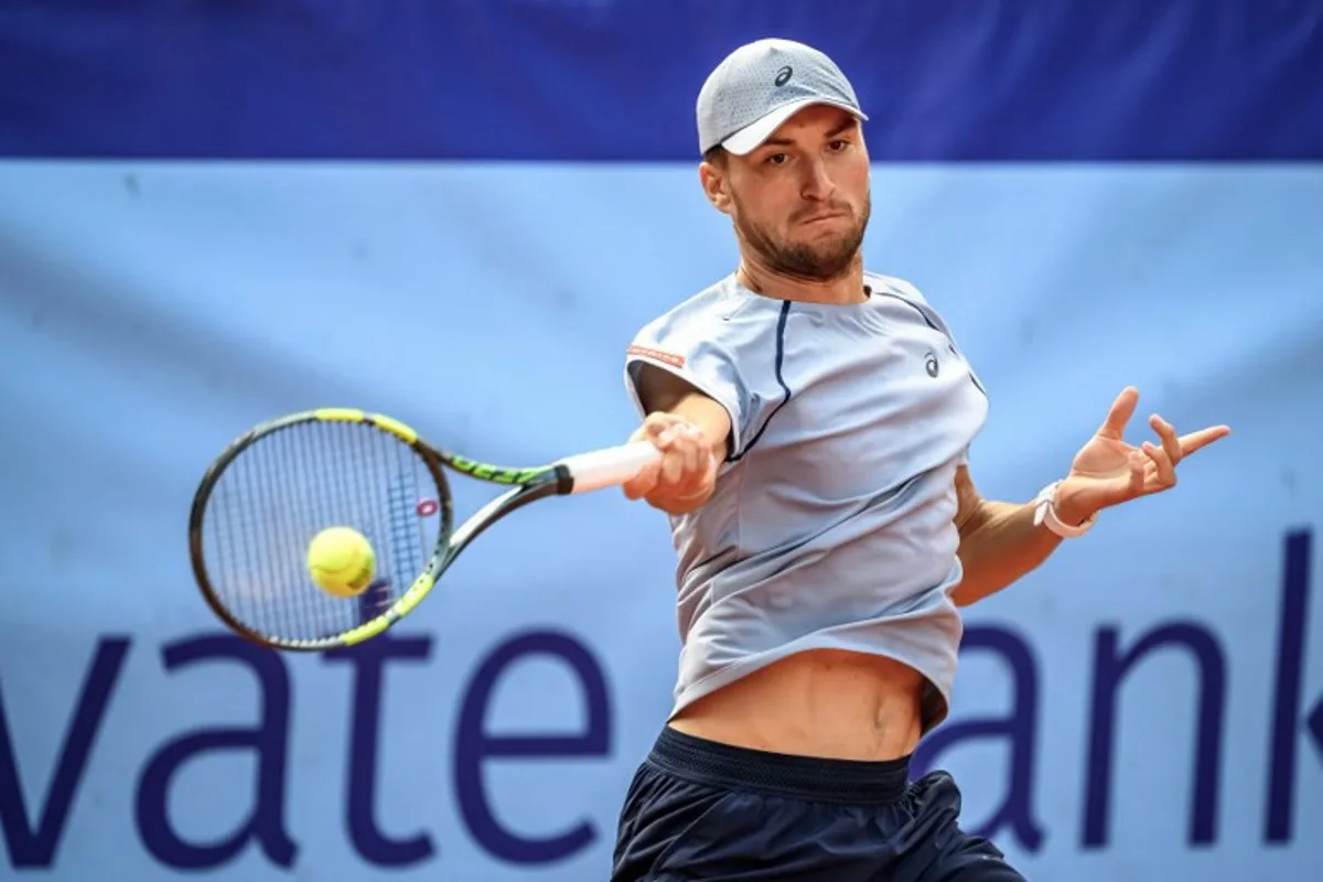 Belgium's Raphael Collignon returns the ball to Greece's Stefanos Tsitsipas during their men's singles final match at the Swiss Open tennis tournament in Gstaad, on July 19, 2026.  Fabrice COFFRINI / AFP