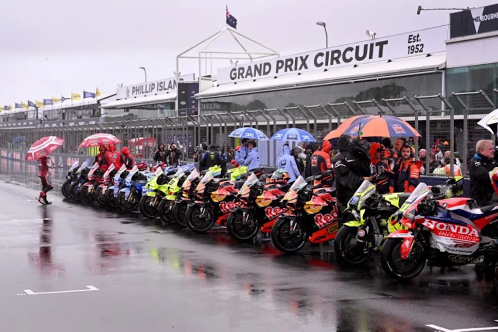 MotoGP bikes are seen lined up after a farewell lap following the cancellation of the last Australian MotoGP Grand Prix to be held at Phillip Island on October 25, 2026, due to inclement weather conditions. Organisers pulled the plug despite a sell-out crowd with persistent rain and poor visibility making racing unsafe. The Moto3 and Moto2 races were also called off. William WEST / AFP