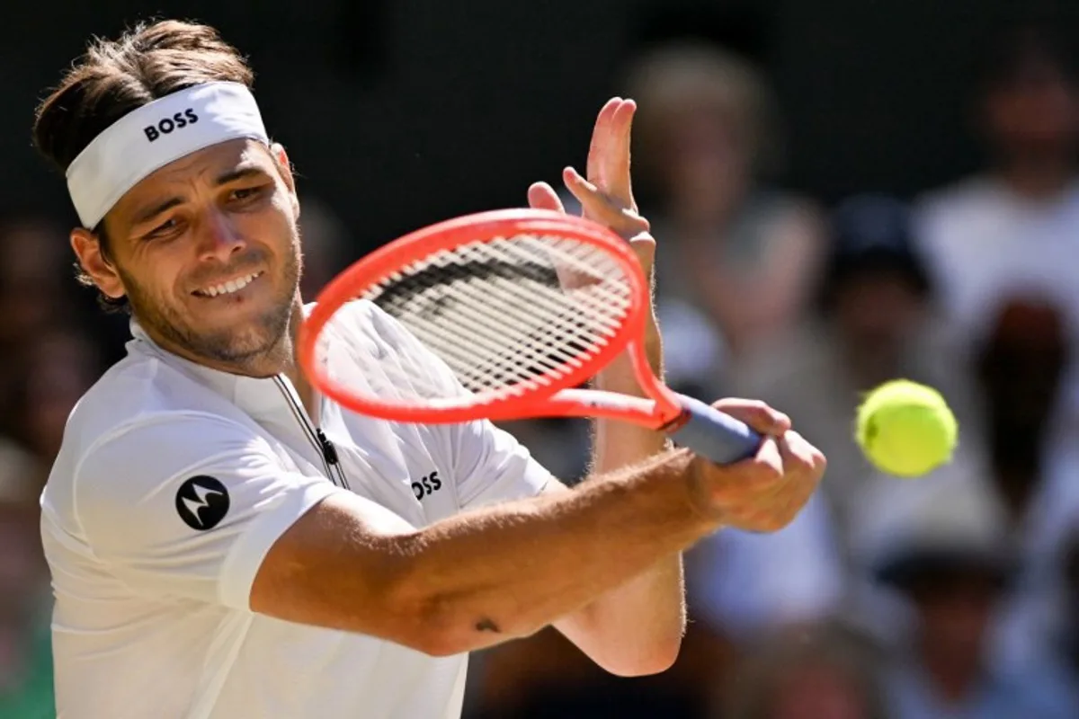 US player Taylor Fritz plays a forehand return to Spain's Carlos Alcaraz during their men's singles semi-final tennis match on the twelfth day of the 2025 Wimbledon Championships at The All England Lawn Tennis and Croquet Club in Wimbledon, southwest London, on July 11, 2025. Glyn KIRK / AFP