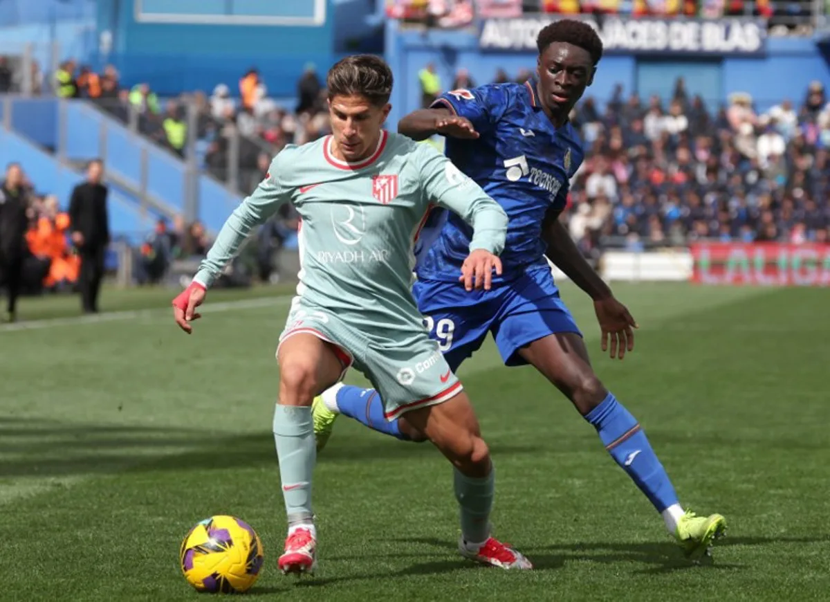 Getafe's Spanish forward #29 Coba da Costa fights for the ball with Atletico Madrid's Argentine forward #22 Giuliano Simeone Lucero during the Spanish league football match between Getafe CF and Club Atletico de Madrid at the Coliseum Alfonso Perez stadium in Getafe on March 9, 2025.  Pierre-Philippe MARCOU / AFP