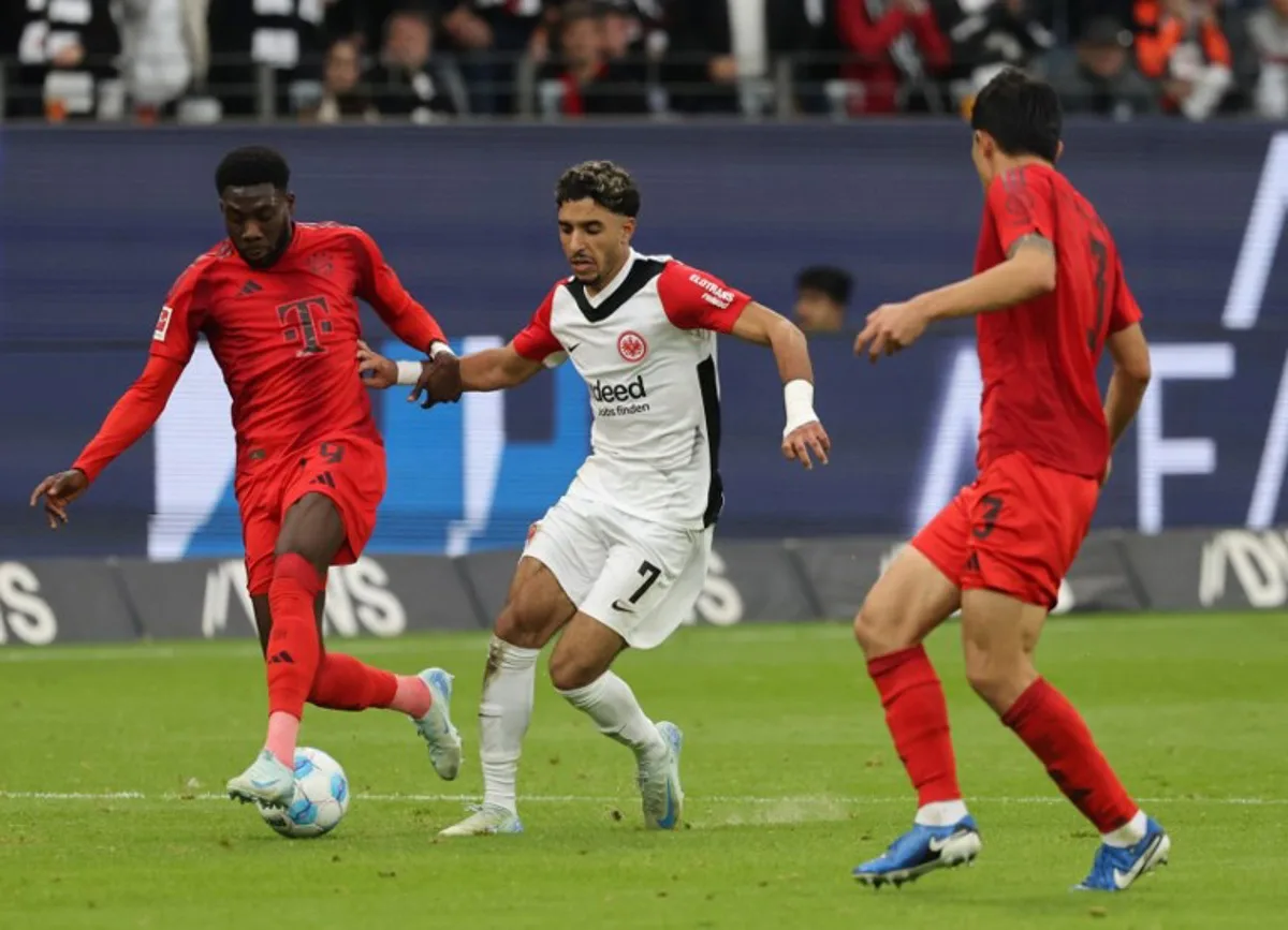 (L-R) Bayern Munich's Canadian defender #19 Alphonso Davies, Frankfurt's Egyptian forward #07 Omar Marmoush and Bayern Munich's South Korean defender #03 Kim Min-Jae vie for the ball during the German first division Bundesliga football match between Eintracht Frankfurt and FC Bayern Munich in Frankfurt, western Germany on October 6, 2024.  Daniel ROLAND / AFP