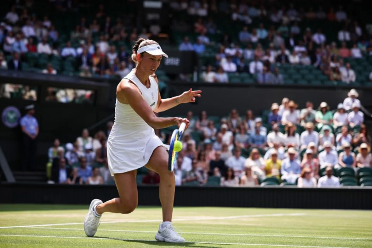 Belgium's Elise Mertens playing with Russia's Veronika Kudermetova returns the ball to Taiwan's Hsieh Su-wei and Latvia's Jelena Ostapenko during their women's doubles final tennis match on the fourteenth day of the 2025 Wimbledon Championships at The All England Lawn Tennis and Croquet Club in Wimbledon, southwest London, on July 13, 2025. HENRY NICHOLLS / AFP