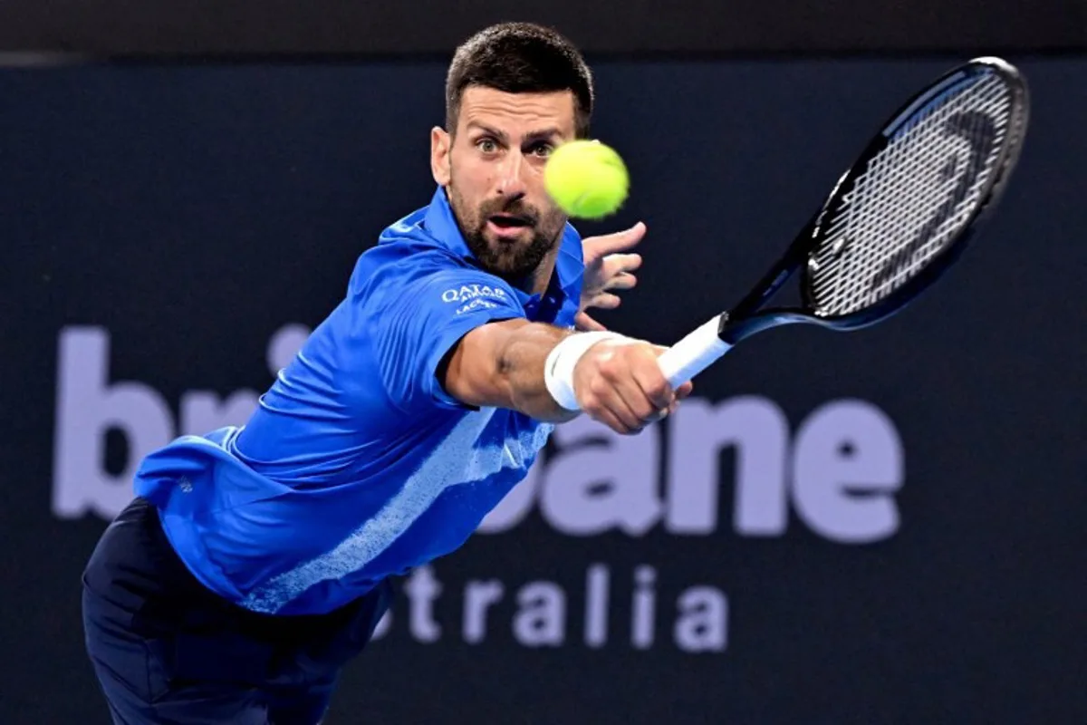 Novak Djokovic of Serbia hits a return with doubles partner Nick Kyrgios of Australia during their men's doubles match against Alexander Erler of Austria and Andreas Mies of Germany at the Brisbane International tennis tournament in Brisbane on December 30, 2024.  William WEST / AFP