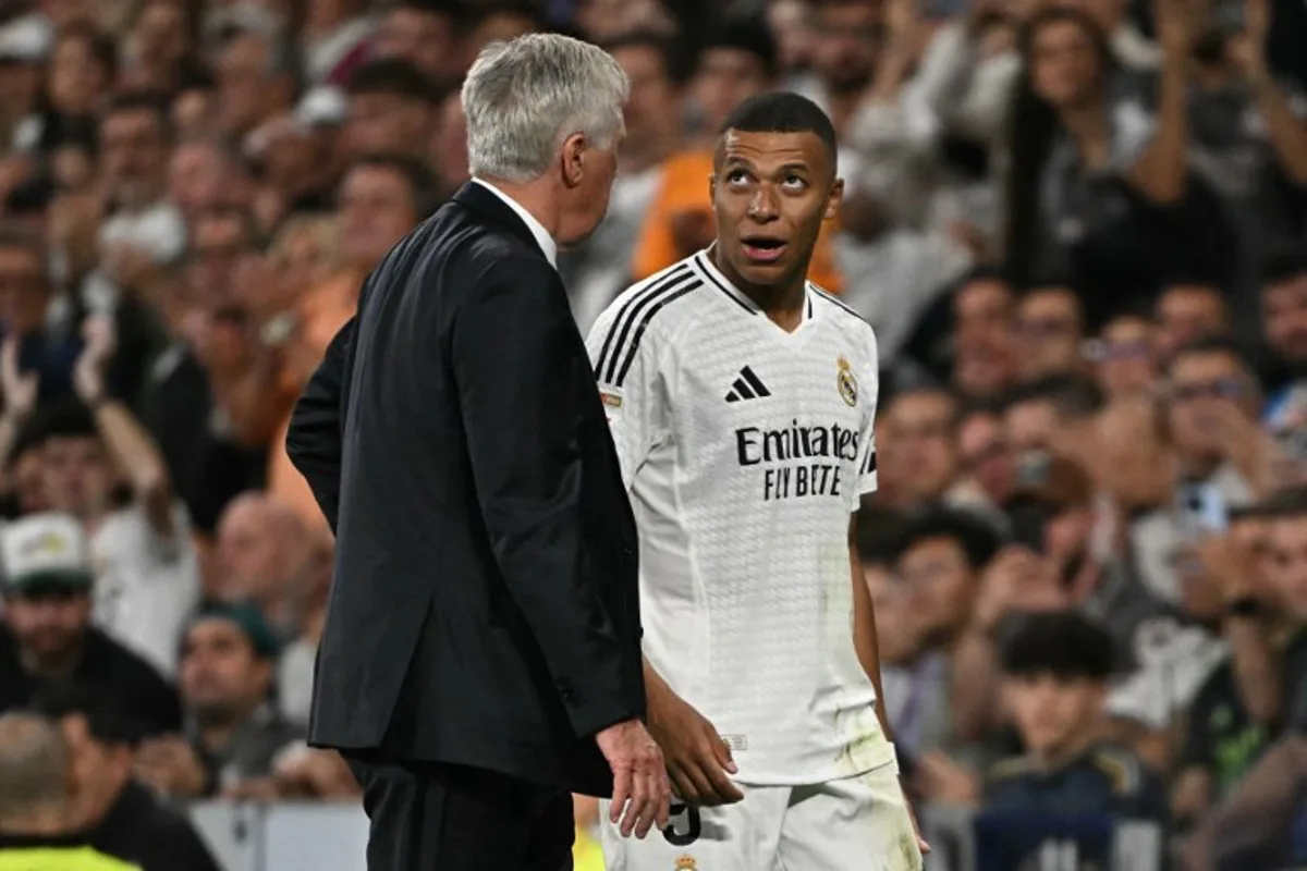 Real Madrid's French forward #09 Kylian Mbappe talks with Real Madrid's Italian coach Carlo Ancelotti as he leaves the pitch during the Spanish league football match between Real Madrid CF and Deportivo Alaves at the Santiago Bernabeu stadium in Madrid on September 24, 2024.  JAVIER SORIANO / AFP