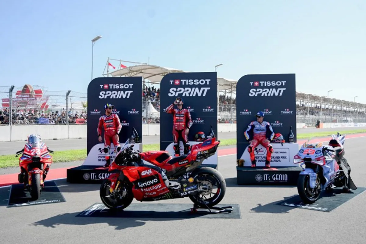 (L-R) Second-placed Ducati Lenovo Team's Italian rider Enea Bastianini, first-placed Ducati Lenovo Team's Italian rider Francesco Bagnaia, and third-placed Gresini Racing MotoGP's Spanish rider Marc Marquez, celebrate on the podium following the MotoGP sprint race of the Indonesian Grand Prix at the Mandalika International Circuit in Mandalika, West Nusa Tenggara on September 28, 2024.  SONNY TUMBELAKA / AFP