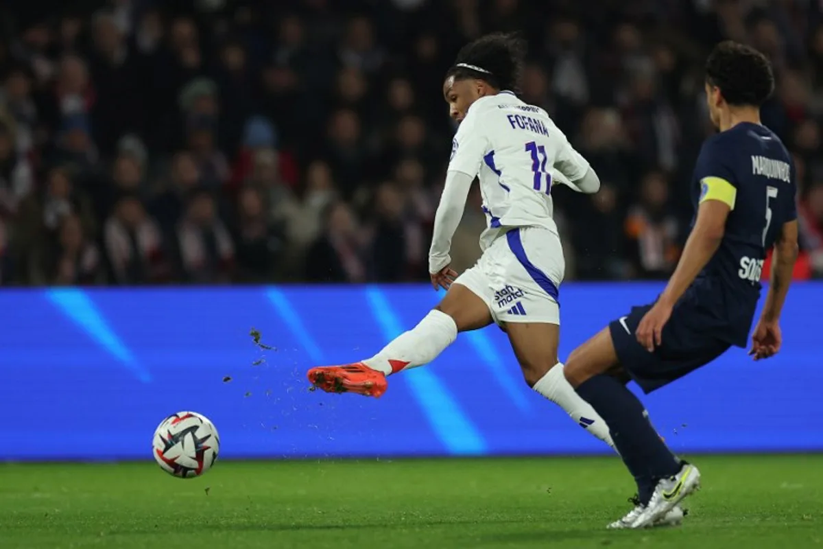 Lyon's Belgian forward #11 Malick Fofana (L) shoots towards goal in front of Paris Saint-Germain's Brazilian defender #05 Marquinhos (R) during the French L1 football match between Paris Saint-Germain and Olympique Lyonnais at the Parc des Princes stadium in Paris on December 15, 2024.  FRANCK FIFE / AFP