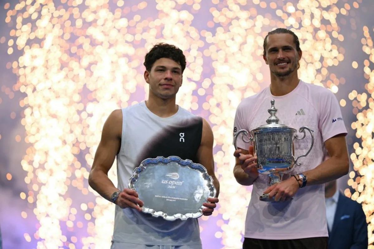USA's Ben Shelton holds the runner-up trophy next to Germany's Alexander Zverev who holds the winner's trophy after the men's singles final tennis match on day fifteen of the US Open tennis tournament at the USTA Billie Jean King National Tennis Center in New York City on September 13, 2026.  ANGELA WEISS / AFP