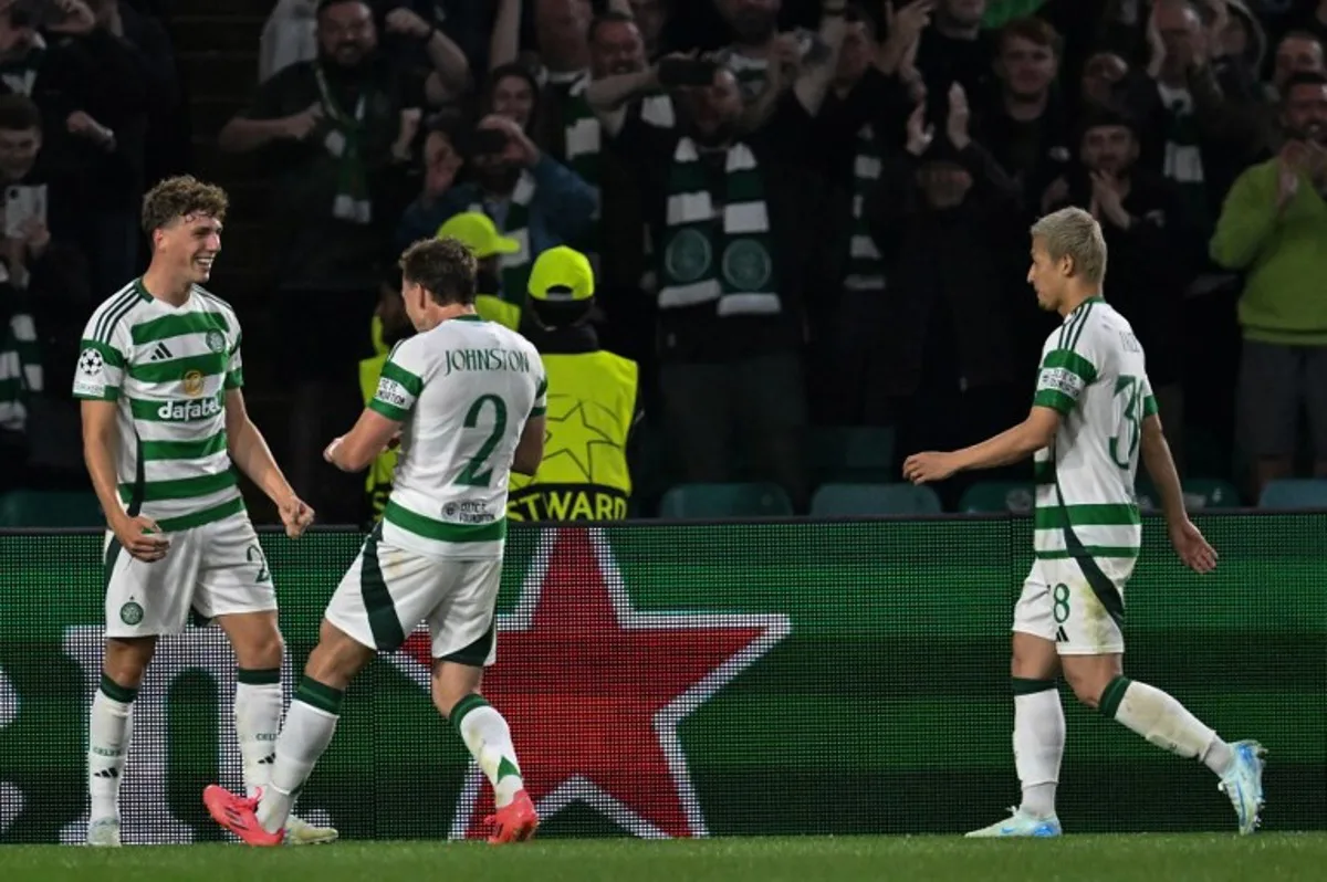 Celtic's Belgian midfielder #27 Arne Engels (L) celebrates after scoring a penalty and his teams third goal during the UEFA Champions League, league phase football match between Celtic and Slovan Bratislava at Celtic Park stadium in Glasgow on September 18, 2024.  ANDY BUCHANAN / AFP