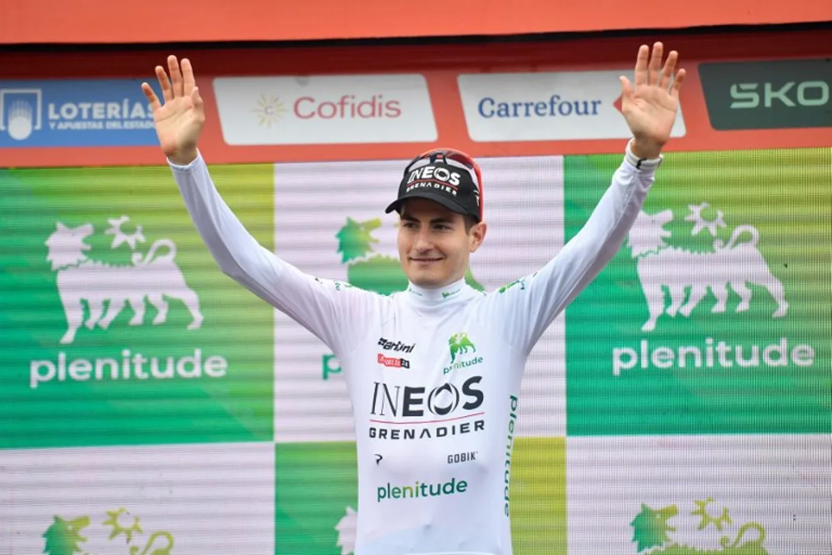 Team Ineos' Carlos Rodriguez wearing the youth ranking leader's white jersey celebrates on the podium after the stage 17 of the Vuelta a Espana, a 141,5 km race between Arnuero and Santander, on September 4, 2024.    Ander Gillenea / AFP