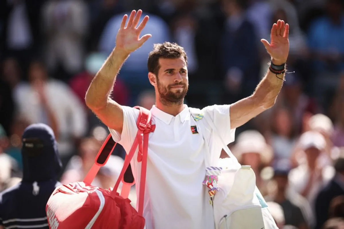 Russia's Karen Khachanov waves to the crowd as he leaves the court after losing against US player Taylor Fritz at the end of their men's singles quarter-final tennis match on the ninth day of the 2025 Wimbledon Championships at The All England Lawn Tennis and Croquet Club in Wimbledon, southwest London, on July 8, 2025. HENRY NICHOLLS / AFP