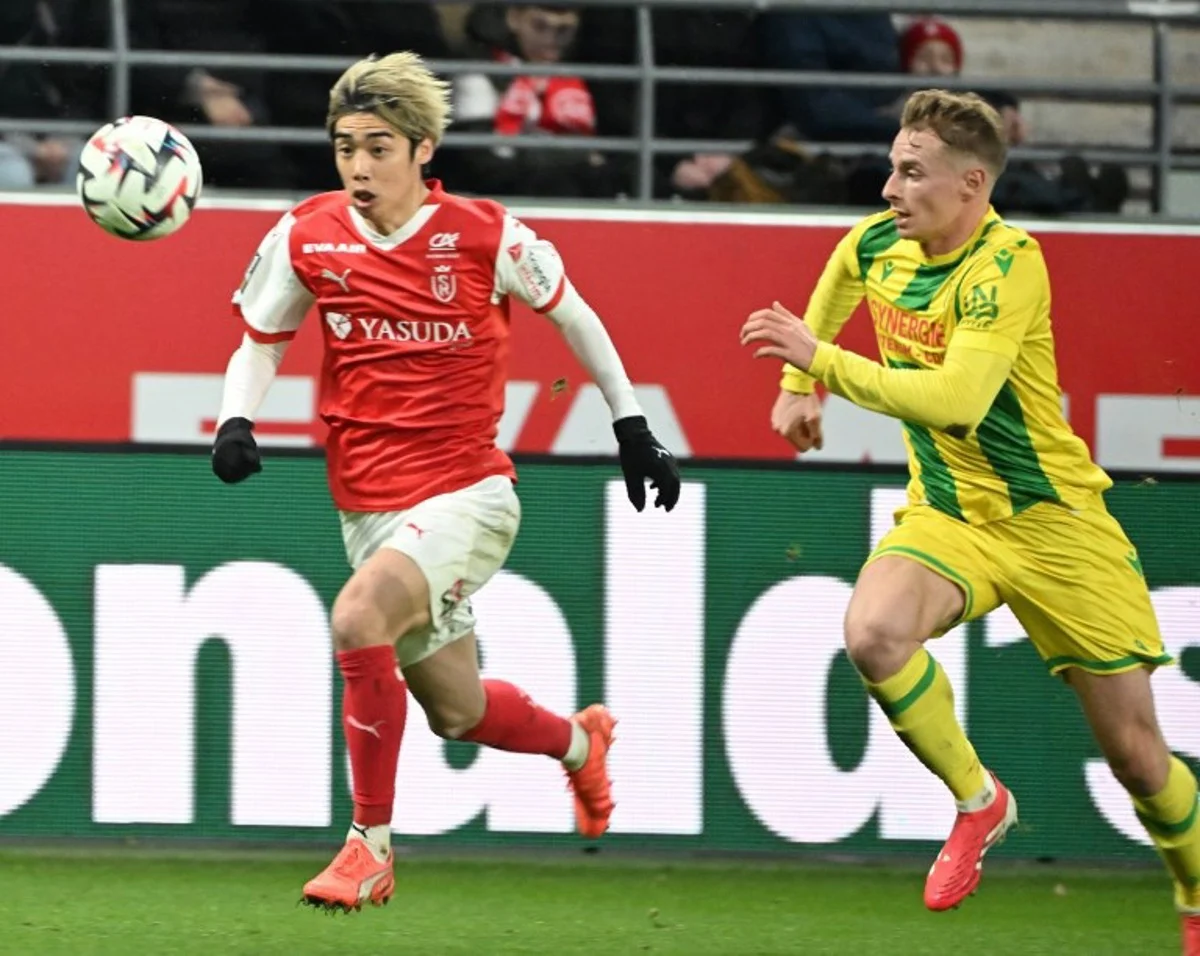 Reims' Japanese forward #07 Junya Ito (L) fights for the ball with Nantes' French defender #03 Nicolas Cozza (R) during the French L1 football match between Stade de Reims and FC Nantes at Stade Auguste-Delaune in Reims, northern France, on February 2, 2025. FRANCOIS NASCIMBENI / AFP