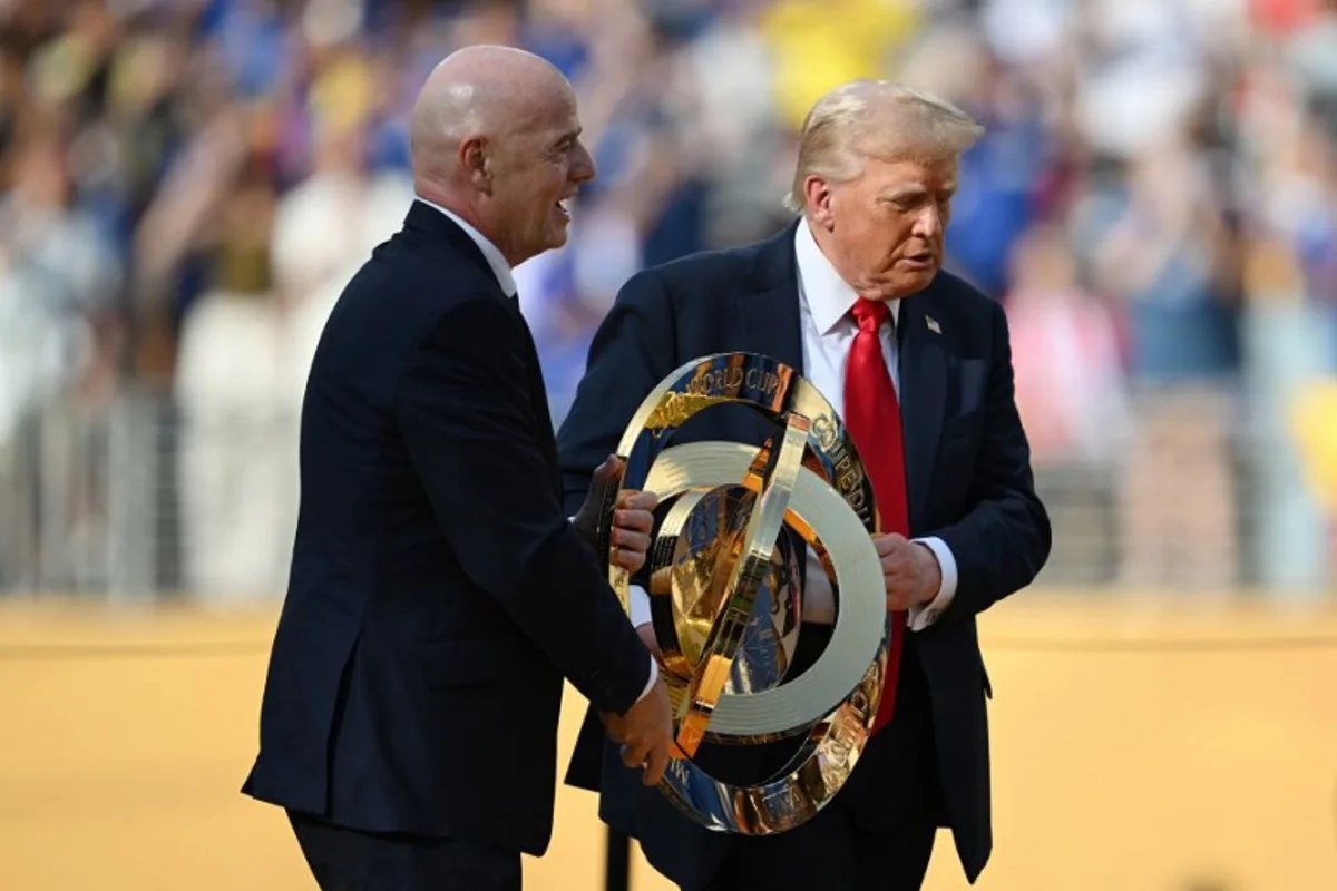 FIFA President Gianni Infantino (L) and US President Donald Trump carry the trophy during the award ceremony for the FIFA Club World Cup 2025 Champions, following the final football match between England's Chelsea and France's Paris Saint-Germain at the MetLife Stadium in East Rutherford, New Jersey on July 13, 2025. ANGELA WEISS / AFP