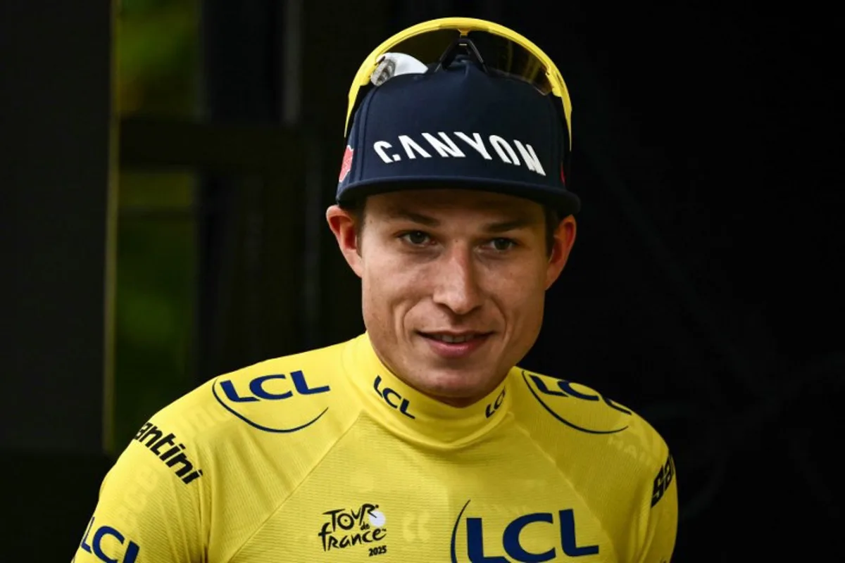 Alpecin - Deceuninck team's Belgian rider Jasper Philipsen celebrates on the podium with the overall leader's yellow jersey after the 1st stage of the 112th edition of the Tour de France cycling race, 184.9 km starting and finishing in Lille Metropole, northern France, on July 5, 2025. Marco BERTORELLO / AFP