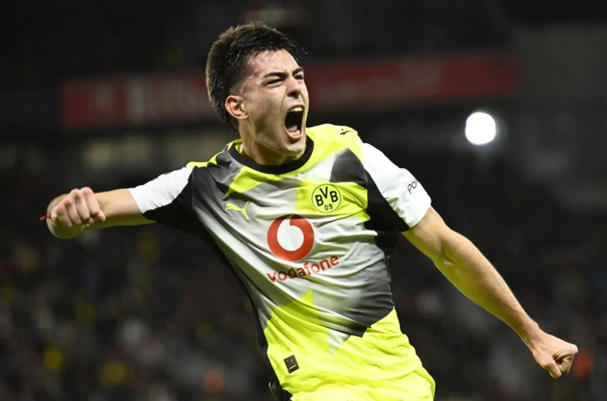 Dortmund's Argentinian defender #28 Aaron Anselmino celebrates his 0-1 during the German first division Bundesliga football match between Bayer 04 Leverkusen and Borussia Dortmund in Leverkusen, western Germany, on November 29, 2025.  INA FASSBENDER / AFP
