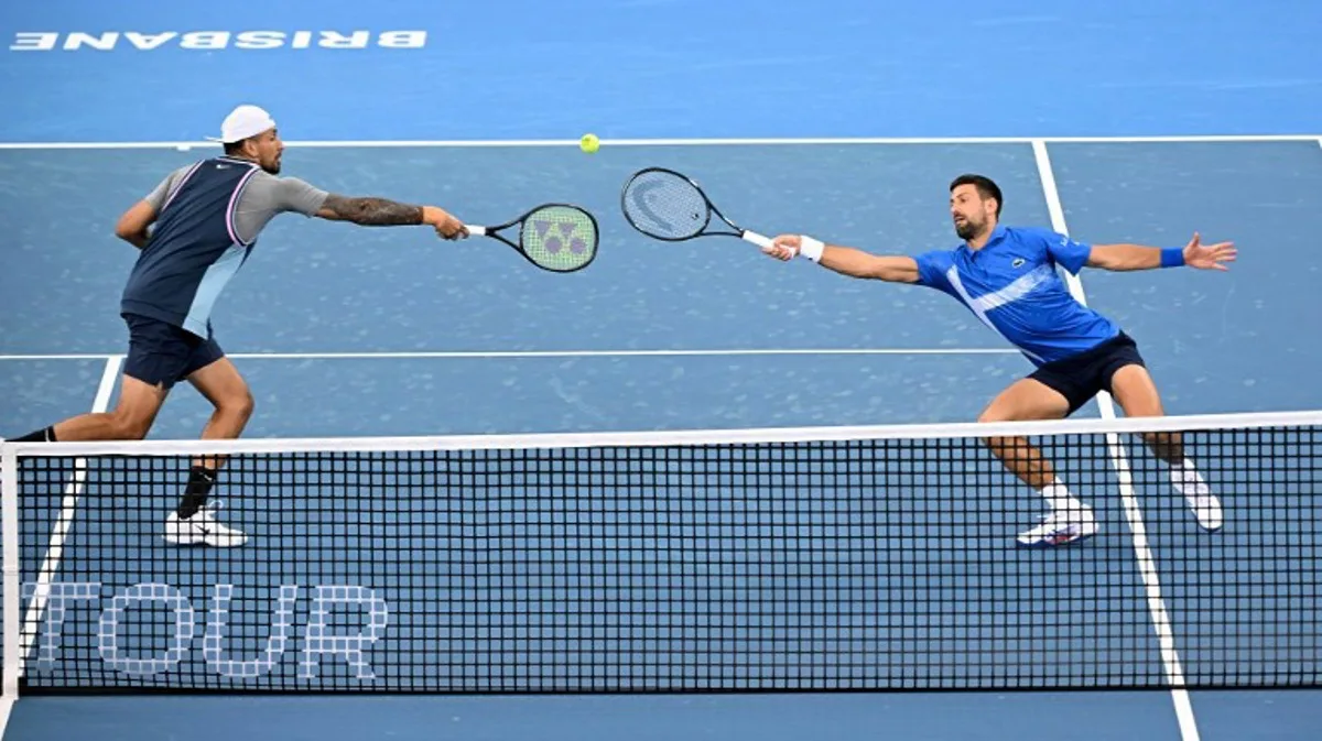 Novak Djokovic of Serbia (R) and Nick Kyrgios of Australia play a point during their men's doubles match against Michael Venus of New Zealand and Nikola Mektic of Croatia at the Brisbane International tennis tournament in Brisbane on January 1, 2025.  William WEST / AFP