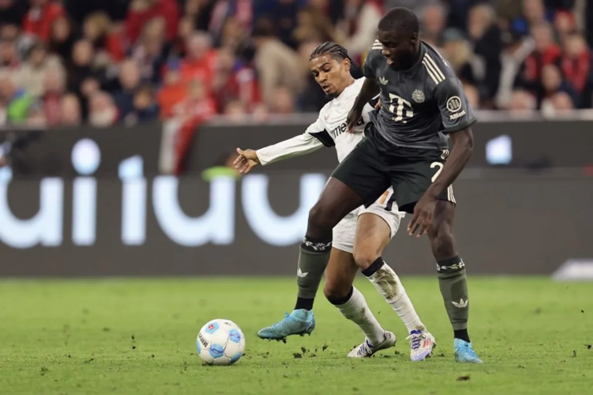 Bayer Leverkusen's French forward #21 Amine Adli (L) and Bayern Munich's French defender #02 Dayot Upamecano vie for the ball during the German first division Bundesliga football match between FC Bayern Munich and Bayer 04 Leverkusen in Munich, southern Germany on September 28, 2024.  Alexandra BEIER / AFP