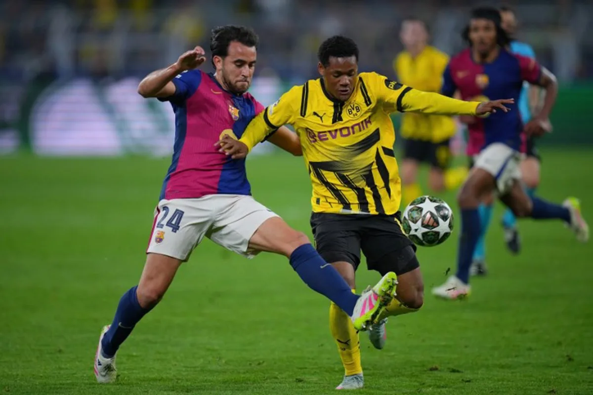 Barcelona's Spanish defender #24 Eric Garcia (L)and Dortmund's Belgian forward #16 Julien Duranville vie for the ball during the UEFA Champions League quarter-final second leg football match between BVB Borussia Dortmund and FC Barcelona in Dortmund, western Germany on April 15, 2025. Pau BARRENA / AFP