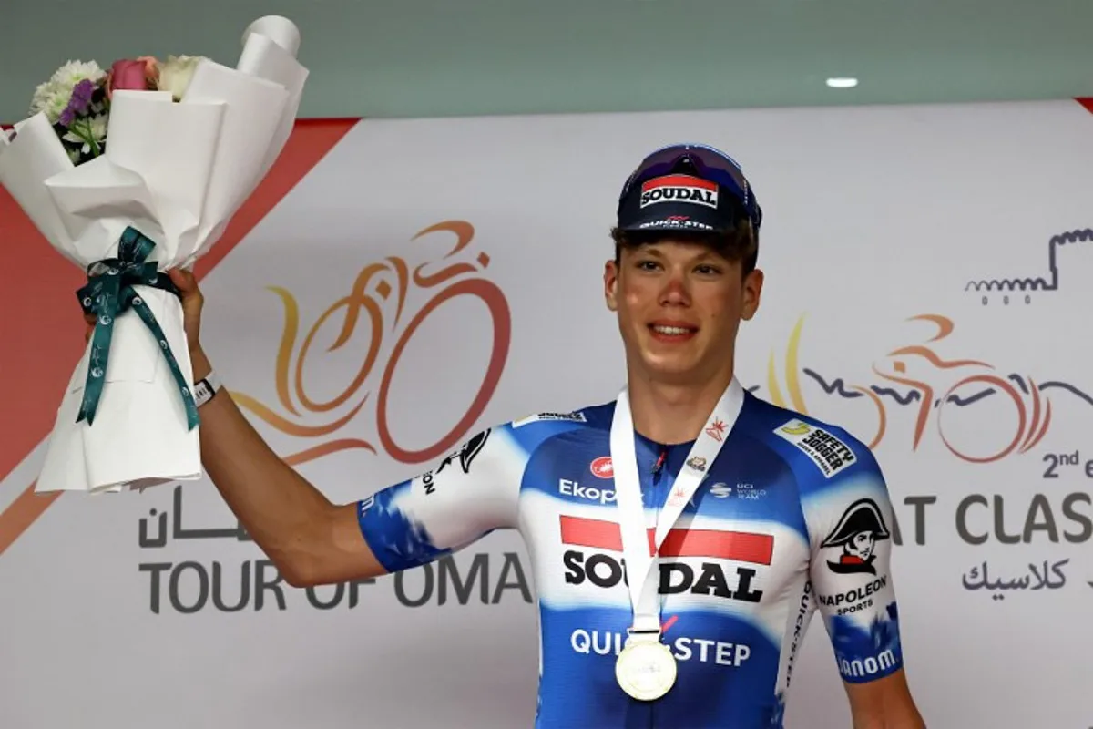 France's Paul Magnier (Soudal Quick-Step) holds flowers on the podium after winning the third stage of the Tour of Oman, shortened to 76 kilometres between Naseem Garden and al-Bustan due to weather conditions, in Muscat on February 12, 2024.  Anne-Christine POUJOULAT / AFP