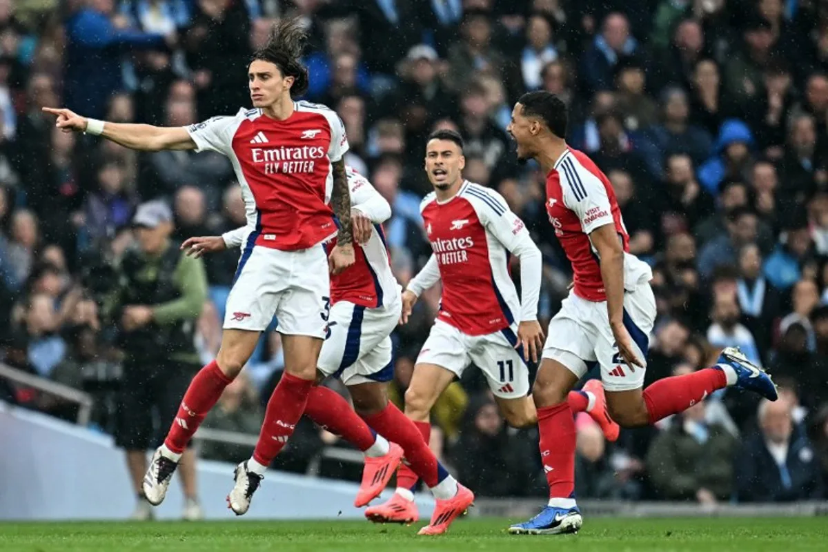 Arsenal's Italian defender #33 Riccardo Calafiori (L) celebrates scoring the team's first goal during the English Premier League football match between Manchester City and Arsenal at the Etihad Stadium in Manchester, north west England, on September 22, 2024.  Paul ELLIS / AFP