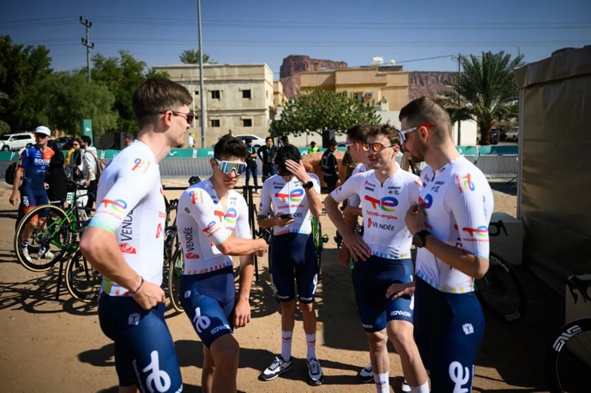 Totalenergies team members waits prior to the start of the first stage of the AlUla Tour cycling race from the Al-Manshiyah Train station to the Al-Manshiyah Train Station, a 142.7 kilometres ride, in Alula, northwestern Saudi Arabia on January 28, 2025. Loic VENANCE / AFP