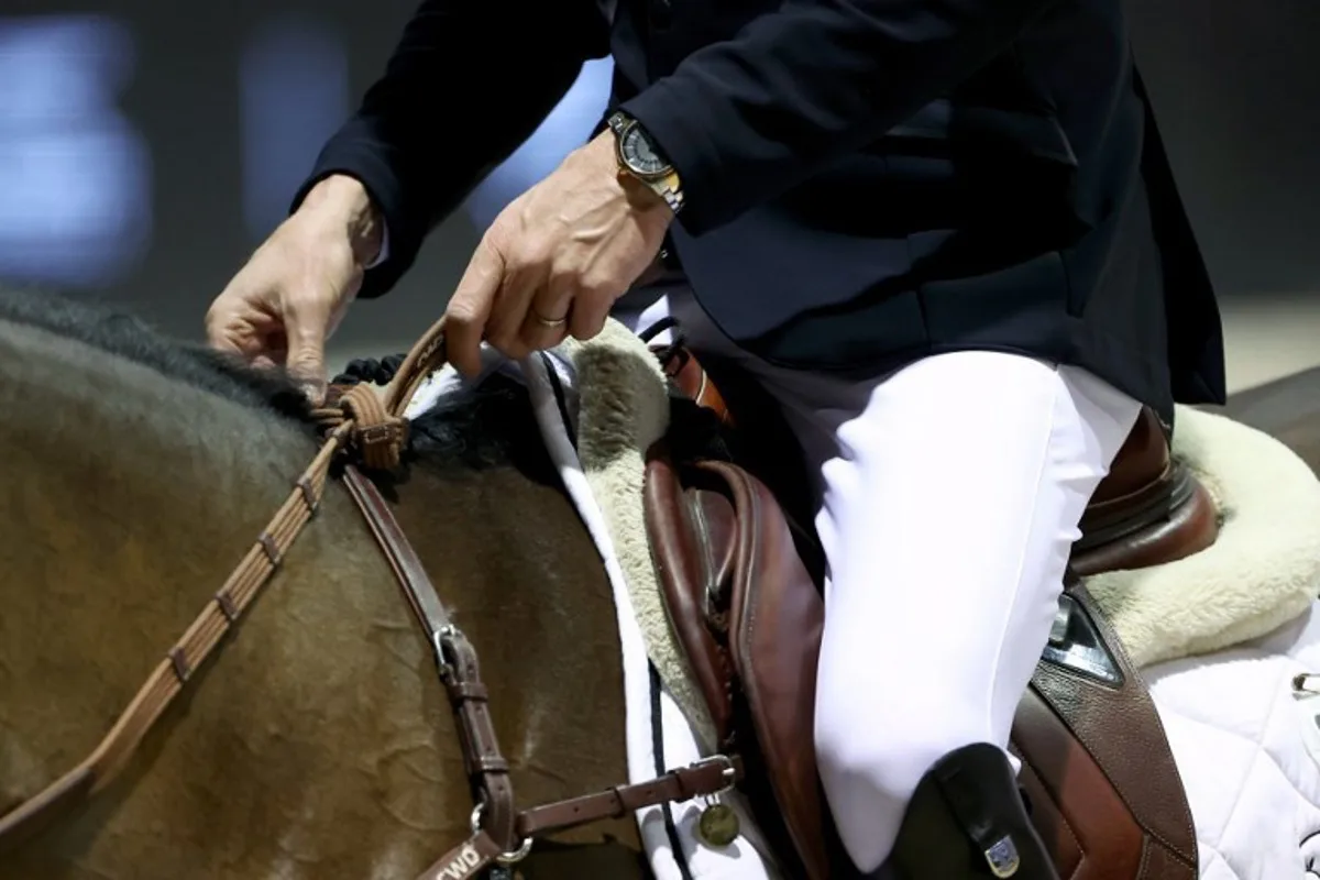 This photograph shows a rider holding his horse's reins during the FEI World Cup Jumping event at the Parc des Expositions in Bordeaux, south-western France, on February 8, 2025.  ROMAIN PERROCHEAU / AFP