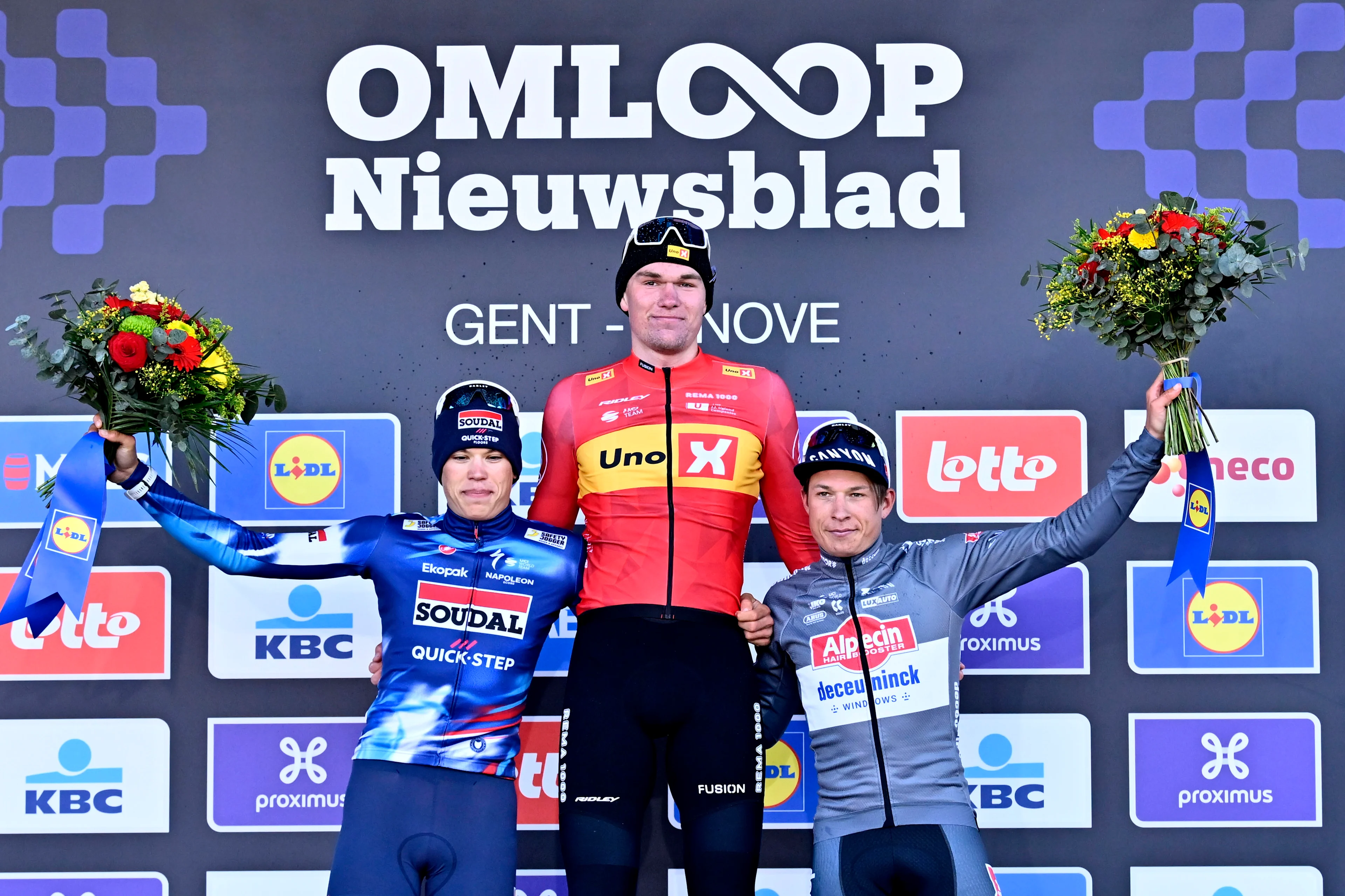 French Paul Magnier of Soudal Quick-Step, Norwegian Soren Waerenskjold of Uno-X Mobility and Belgian Jasper Philipsen of Alpecin-Deceuninck celebrate on the podium of the men's one-day cycling race Omloop Het Nieuwsblad (UCI World Tour), 197km from Gent to Ninove, Saturday 01 March 2025. BELGA PHOTO DIRK WAEM