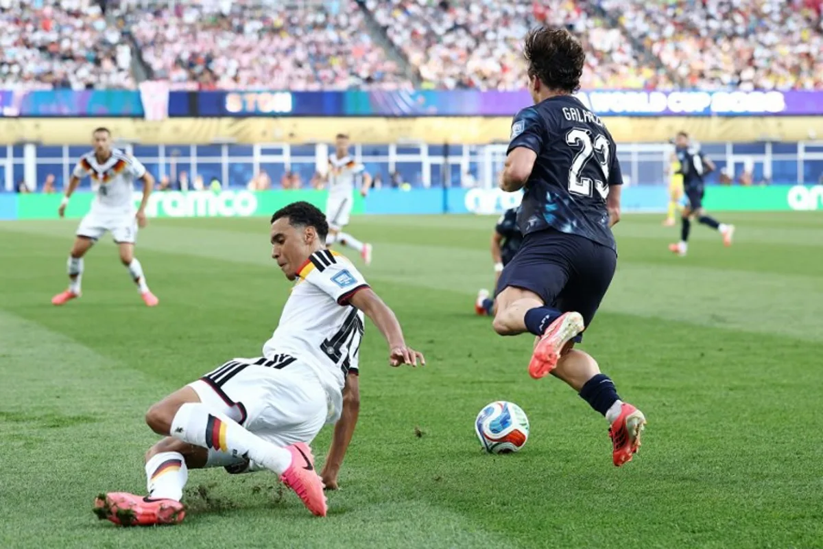 Germany's midfielder #10 Jamal Musiala (L) fouls Paraguay's midfielder #23 Matias Galarza during the 2026 World Cup round of 32 football match between Germany and Paraguay at the Boston Stadium in Foxborough on June 29, 2026. CHARLY TRIBALLEAU / AFP