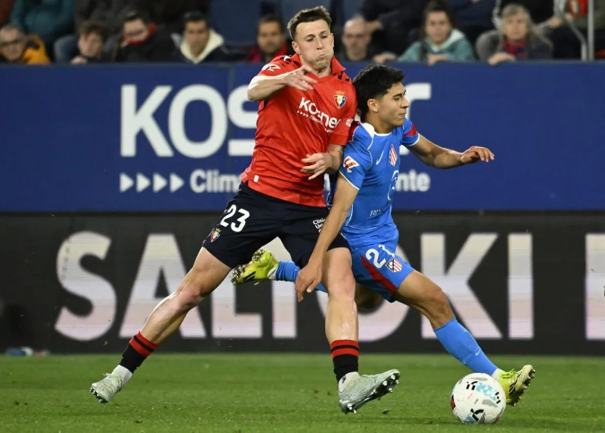 Osasuna's Spanish defender #23 Abel Bretones fights for the ball with Atletico Madrid's US midfielder #21 Obed Vargas during the Spanish league football match between CA Osasuna and Club Atletico de Madrid at El Sadar Stadium in Pamplona on May 12, 2026. ANDER GILLENEA / AFP