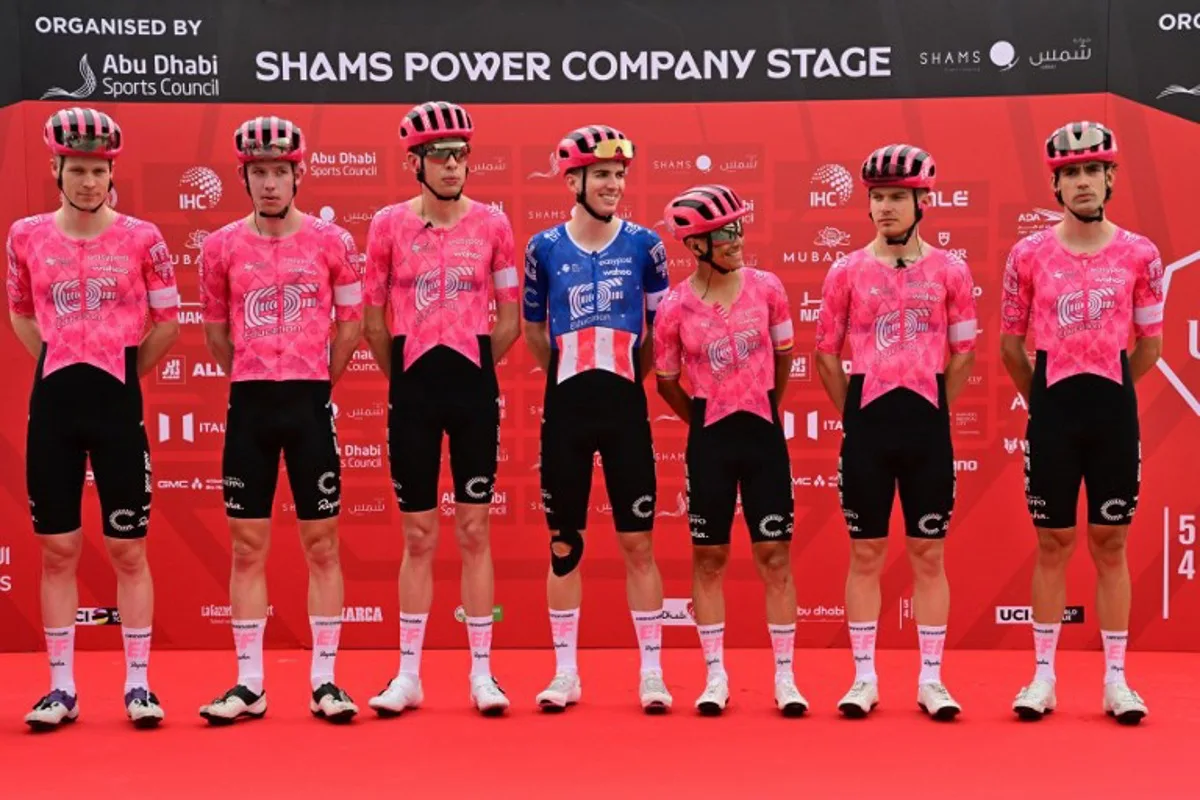 Members of team EF Education-Easypost pose on the podium before the start of the first stage of the UAE Tour cycling race from Shams Solar Power Station Madinat Zayed to Liwa Palace in Abu Dhabi on February 17, 2025.  Giuseppe CACACE / AFP