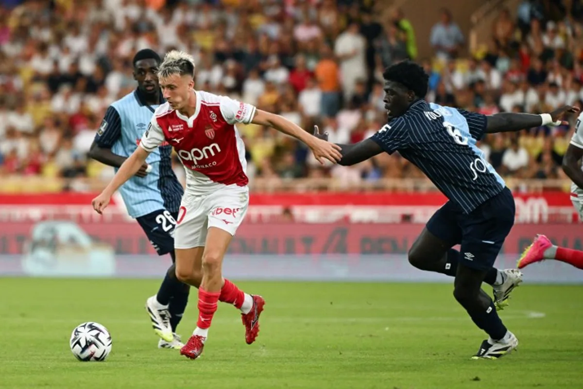 Monaco's Russian midfielder #10 Aleksandr Golovin and Le Havre's French defender #06 Etienne Youte Kinkoue (R) fight for the ball during the French L1 football match between AS Monaco and Le Havre AC at the Louis II Stadium (Stade Louis II) in the Principality of Monaco on August 16, 2025. Miguel MEDINA / AFP