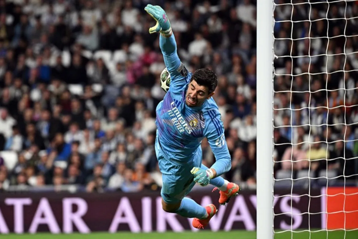 Real Madrid's Belgian goalkeeper #01 Thibaut Courtois lunges for the ball before Manchester City's Spanish midfielder #14 Nico Gonzalez (out of frame) scored their first goal during the UEFA Champions League knockout phase play-off football match between Real Madrid CF and Manchester City at the Santiago Bernabeu stadium in Madrid on February 19, 2025.  JAVIER SORIANO / AFP