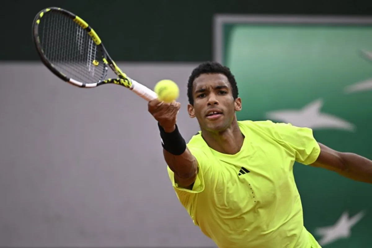 Canada's Felix Auger-Aliassime plays a backhand return to Italia's Matteo Arnaldi during their men's singles match on day 3 of the French Open tennis tournament at the Roland-Garros Complex in Paris on May 27, 2025. JULIEN DE ROSA / AFP