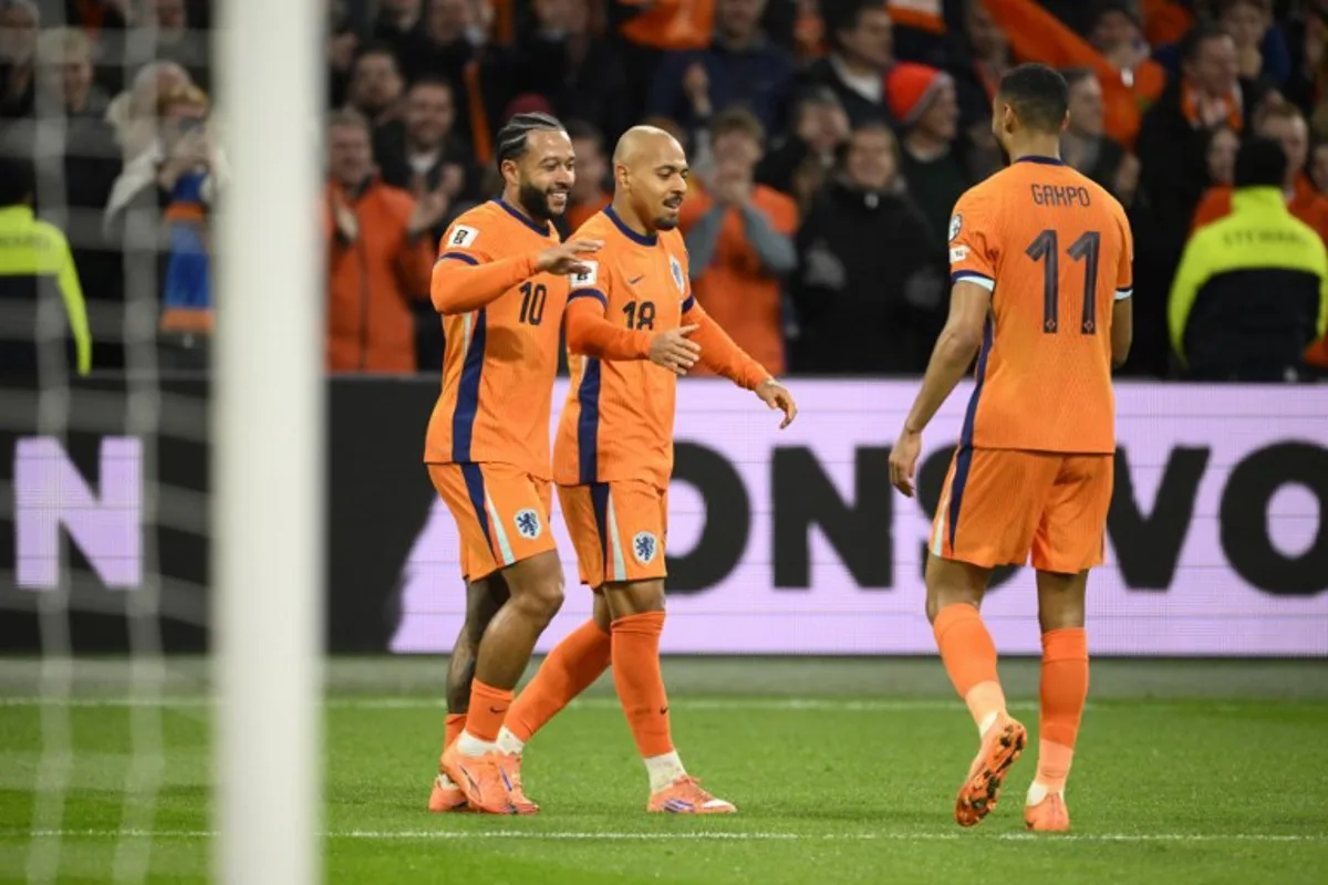 Netherlands' forward #18 Donyell Malen (C) celebrates after scroing the Netherlands fourth goal with Netherlands' forward #10 Memphis Depay (L) and Netherlands' forward #11 Cody Gakpo (R) during the FIFA World Cup 2026 Group G European qualification football match between the Netherlands and Lithuania at the Johan Cruijff Arena, in Amsterdam, on November 17, 2025. JOHN THYS / AFP