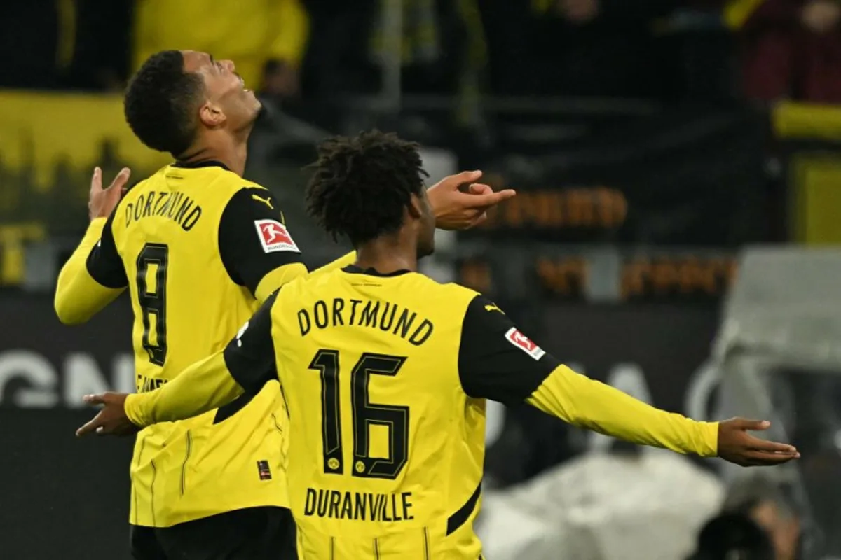 Dortmund's German midfielder #08 Felix Nmecha celebrates scoring the 4-2 goal with his teammate Dortmund's Belgian forward #16 Julien Duranville during the German first division Bundesliga football match between BVB Borussia Dortmund and VfL Bochum in Dortmund, western Germany on September 27, 2024.  INA FASSBENDER / AFP