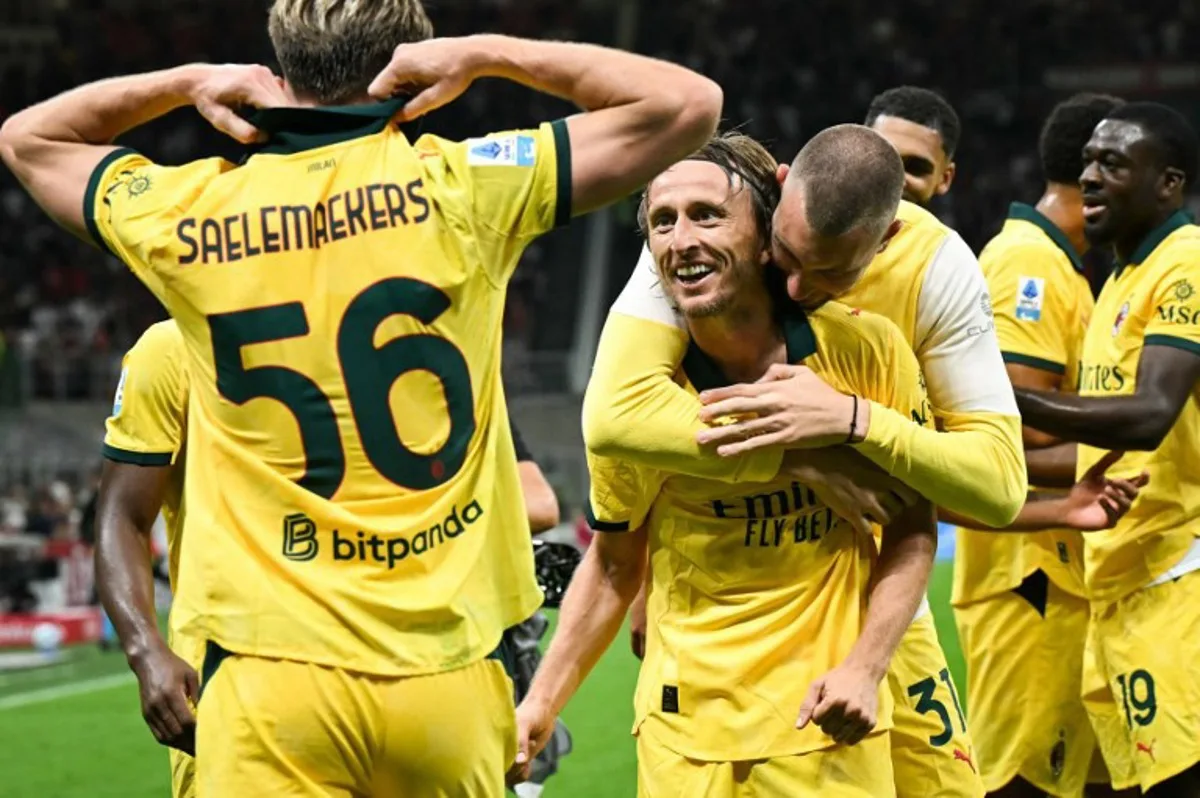AC Milan's Croatian midfielder #14 Luka Modric (C) celebrates with teammates after scoring his team first goal during the Italian Serie A football match between AC Milan and Bologna at San Siro stadium in Milan, northern Italy, on September 14, 2025. Stefano RELLANDINI / AFP