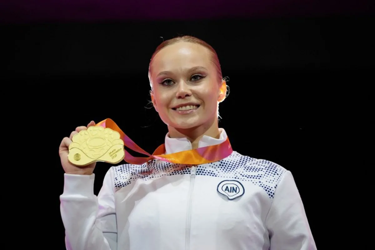 First-placed Individual Neutral Athlete (AIN) Angelina Melnikova (C) with the gold medal poses during the victory ceremony for the women's vault final at the 53rd FIG Artistic Gymnastics World Championships in Jakarta on October 24, 2025. Yasuyoshi CHIBA / AFP